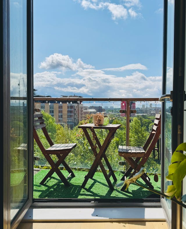 Słoneczny balkon południowy ze stolikiem i krzesłami